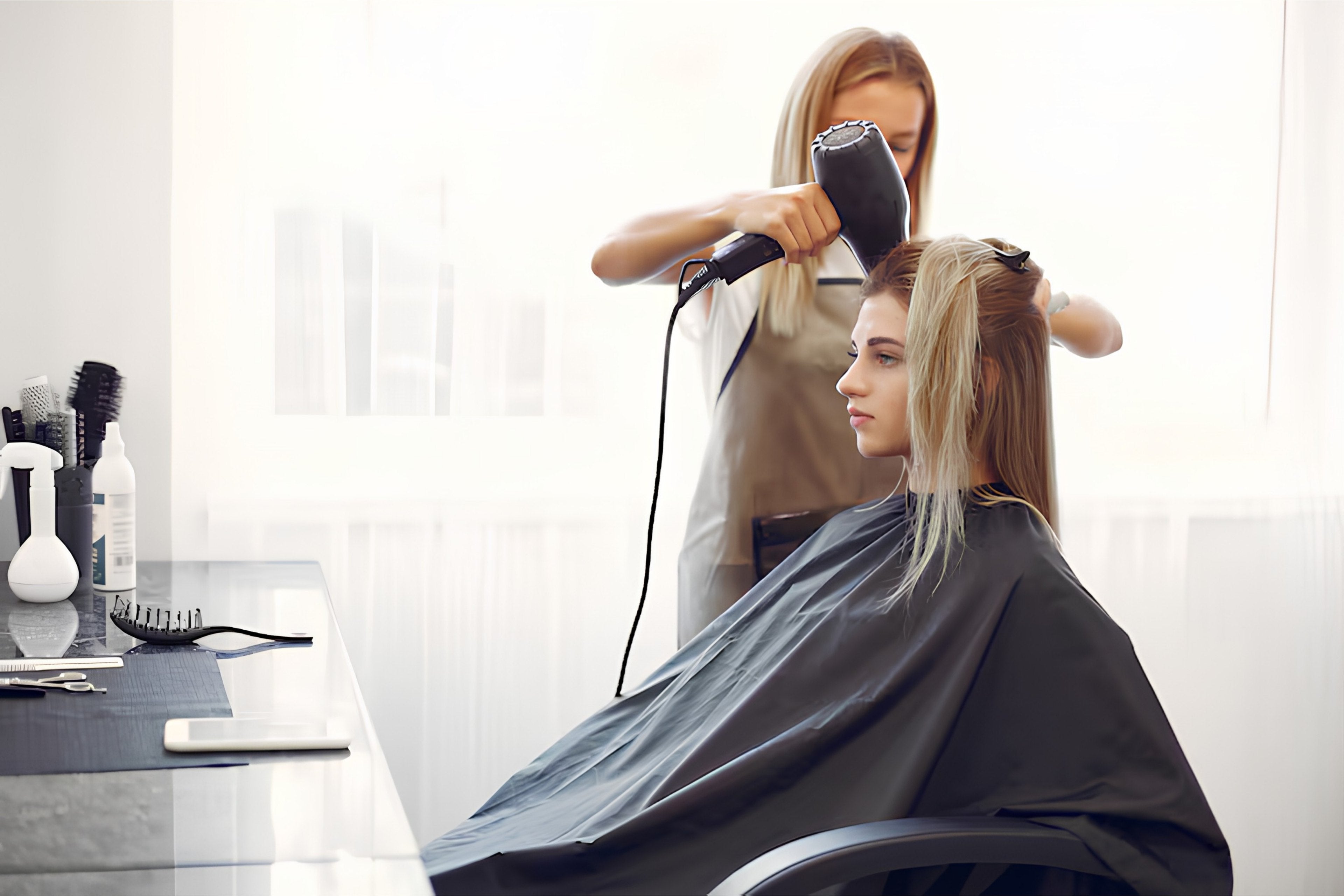 Peluquera secando el pelo a una clienta en la peluquería